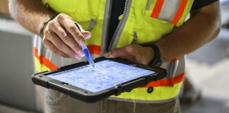 engineer using a construction management software on his ipad