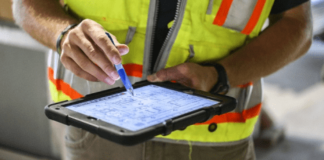 engineer using a construction management software on his ipad 